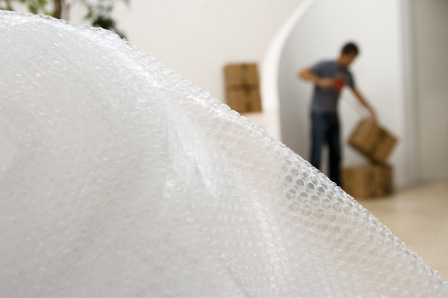 bubblewrap and man sealing box with tape